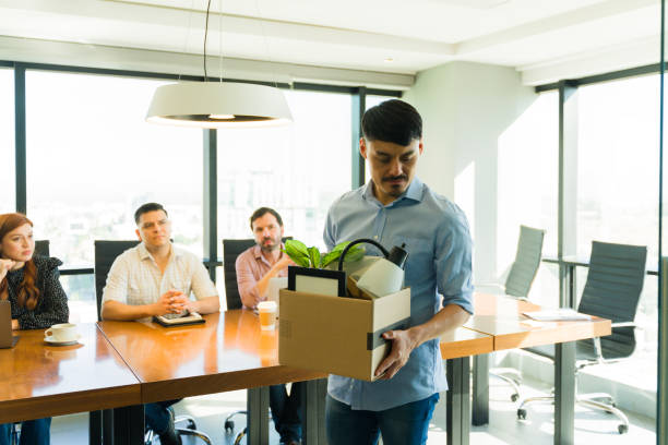 istock Sad looking Hispanic man getting his stuff in a box and leaving the office after getting fired 1927273485