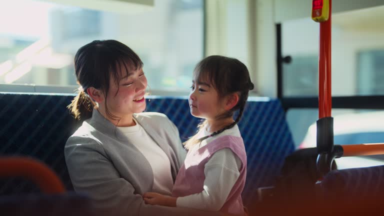 Businesswoman commuting by bus with her small daughter