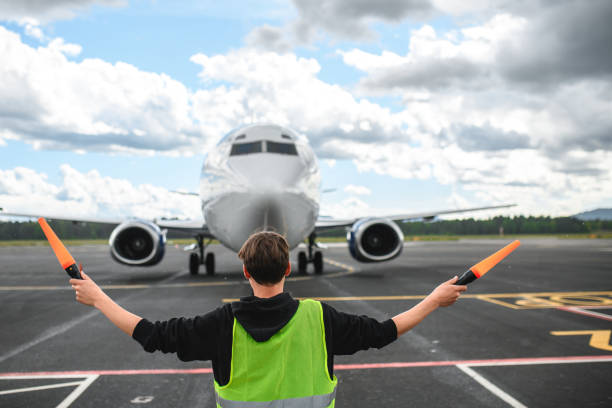 istock Caucasian Airport Worker Marshalling An Aircraft 1927313466