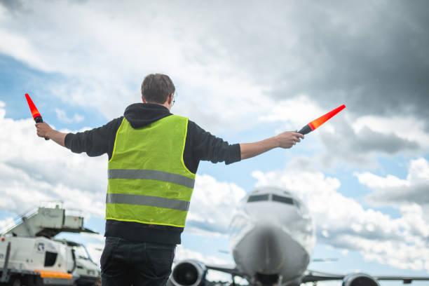 istock Caucasian Airport Worker Marshalling An Aircraft 1927313469