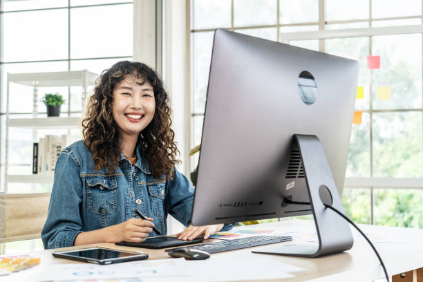 istock Young Asian graphic designer woman working in an office with a computer 1927317172