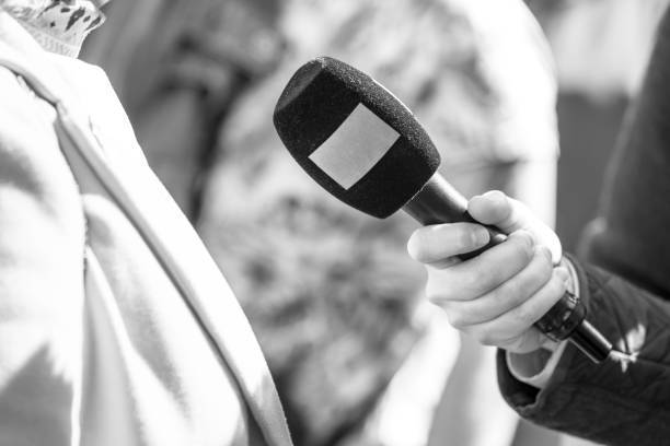 istock Journalist holding microphone making media or vox populi interview 1927335257
