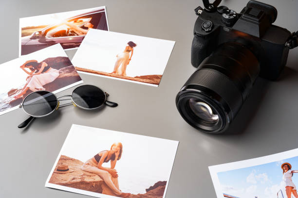 istock Photo camera with colorful printer photos on gray desk 1927346372