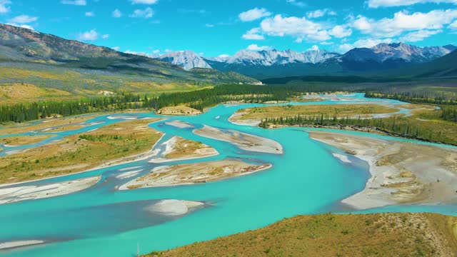 Drone flies over beautiful river with crystal clear blue water in jasper national park of Canada