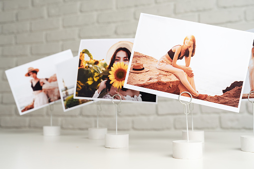 Printed colorful photos of women portraits. Printing photos hobby concept