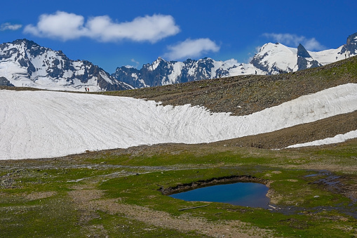 Beautiful landscape with a glacial lake and mountains covered with snow in Dombay, Russia