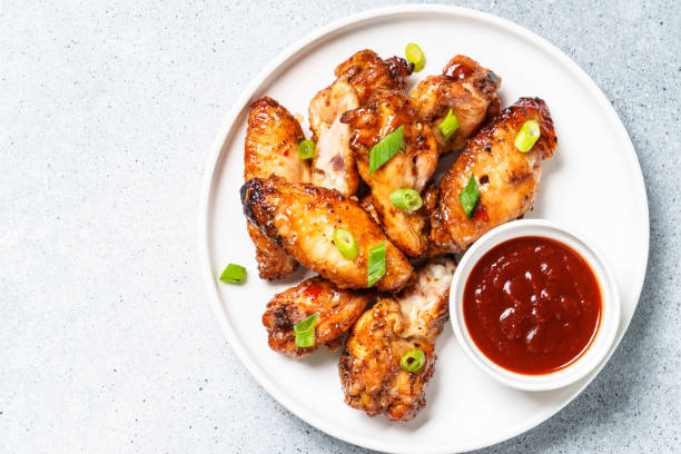 istock Chicken wings in bbq sauce at white table. 1927362843