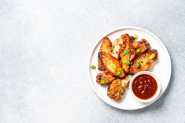 istock Chicken wings in bbq sauce at white table. 1927362845