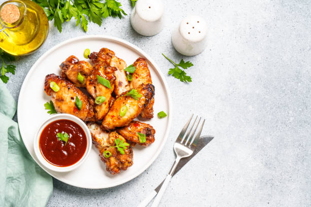 istock Chicken wings in bbq sauce at white table. 1927363890