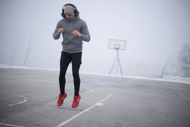 a young man warms up before running in cold foggy weather