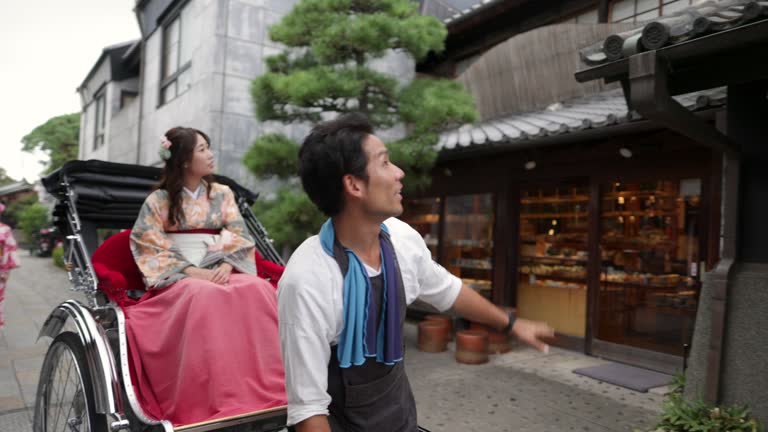 Woman in Kimono / Hakama on rickshaw ride in traditional Japanese town