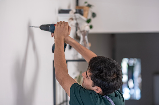 Young repairman repairing electrical outlet at home