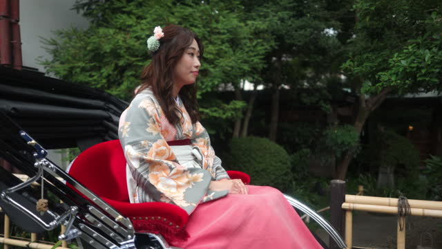 Woman in Kimono / Hakama on rickshaw ride in traditional Japanese town