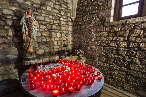 Church of Saint Francis and its monastery at Krk town, Krk island Croatia - the chapel's interior. Candles with the Virgin Mary statue.