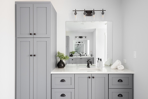 A bathroom detail with a grey cabinet and white countertop.