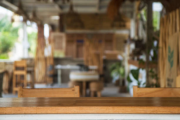 Empty wood table top and blurred bokeh restaurant, cafe and coffee shop interior background
