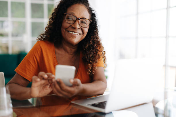 istock Happy mature woman using a mobile phone in her home office 1927472094