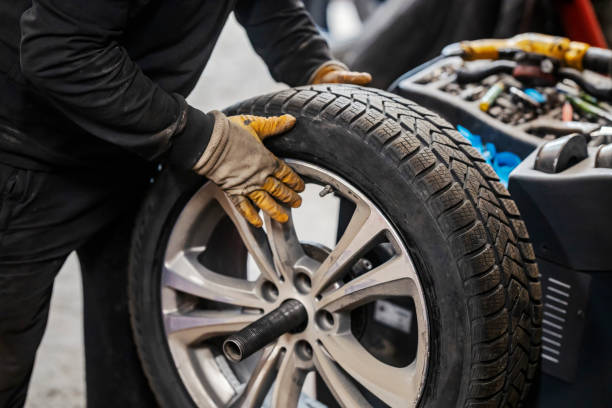 istock Mechanic's hands balancing car wheel. 1927475828