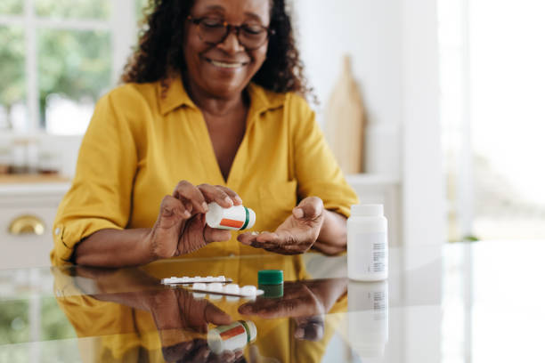 istock Medication adherence: Mature woman taking tablets for a chronic health condition 1927476884