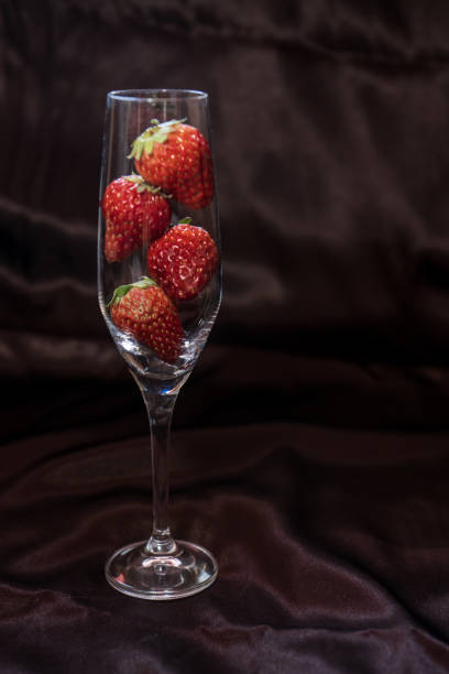 Strawberry in a glass on a brown background