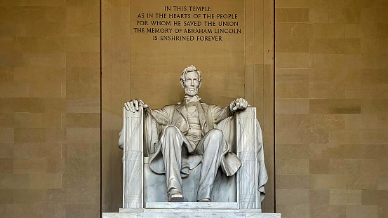 The monument and statue of Abraham Lincoln sitting in a chair at the National Mall Memorial in Washington DC (USA).