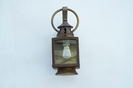 A decorative black hanging gas lantern with flame burning.