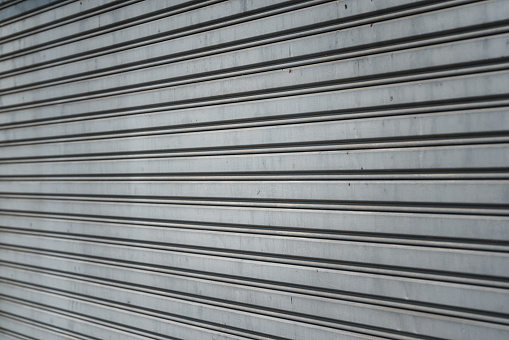 Closed metal grate rolling door of the warehouse storage or service garage.