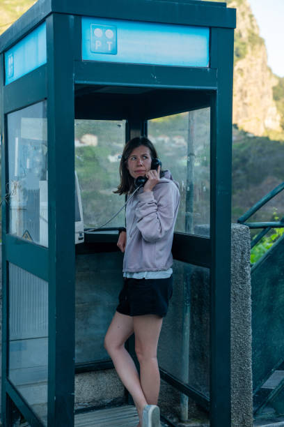 Female tourist calling from a telephone booth