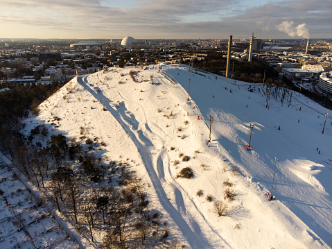 The only ski resort in Stockholm city, near the district of Hammarby, with new snow, cold winter day, panorama of the southern suburbs of Stockholm in the background with the Ericsson Globe.