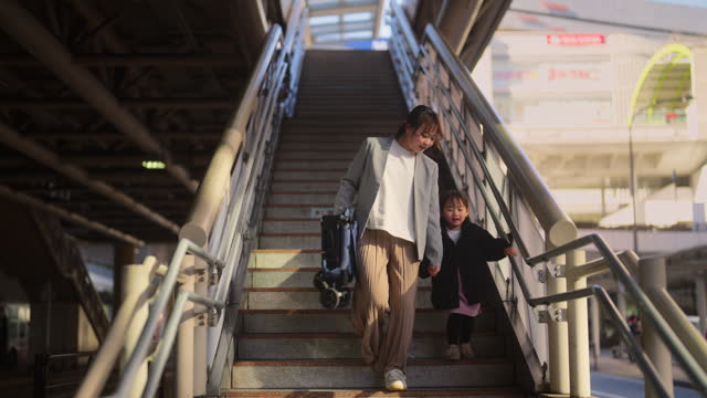 Businesswoman walking at bus station while commuting with her small daughter