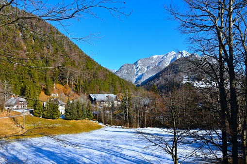 Srednji vrh village in Karavanke mountains bellow forest covered slopes in Gorenjska, Slovenia