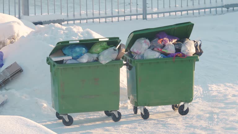 Overflowing garbage cans in winter, storage and collection of waste