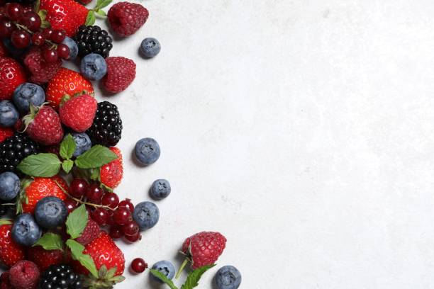 istock Many different fresh ripe berries on white textured table, flat lay. Space for text 1927629409