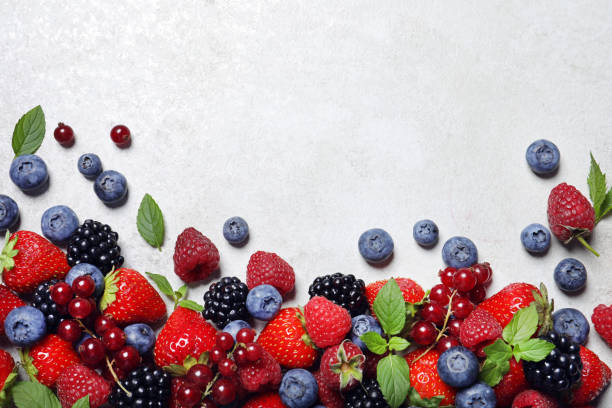 istock Many different fresh ripe berries on white textured table, flat lay. Space for text 1927631014