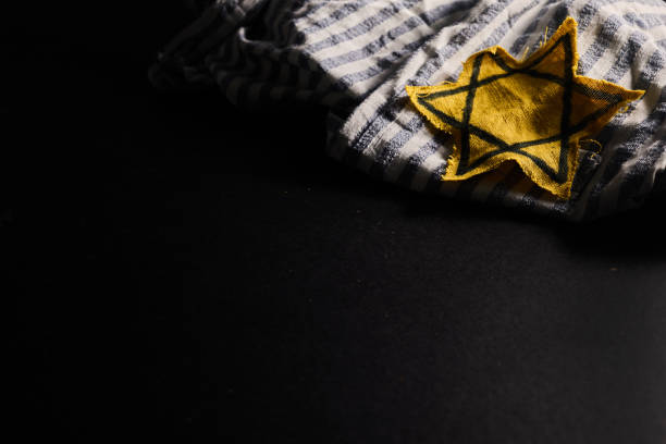 Holocaust memory day. Arbed wire and burning candle on black background