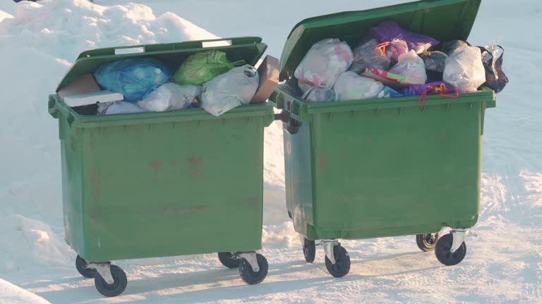 Overflowing garbage cans in winter, storage and collection of waste