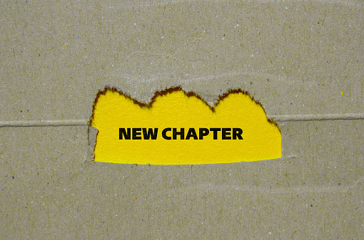 New chapter lettering on ripped paper with yellow background. Business concept photo. Top view, copy space.