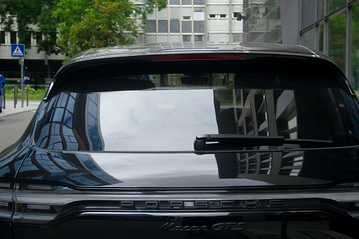 Stuttgart, Baden-Wuerttemberg, Germany, Europe - August 16, 2021 - Boerse Stuttgart Financial District Modern Office Towers Reflection on Surface of Porsche Macan GTS Luxury Sport Car, Calwer Street Neighborhood, Stuttgart-Mitte Stuttgart-Center District, Stuttgart City Center, Southern Germany, Western Europe