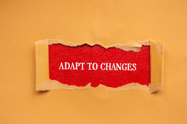 istock Adapt to changes lettering on ripped orange paper with red background 1927658017
