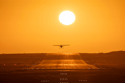 Small airplane taking off at sunset