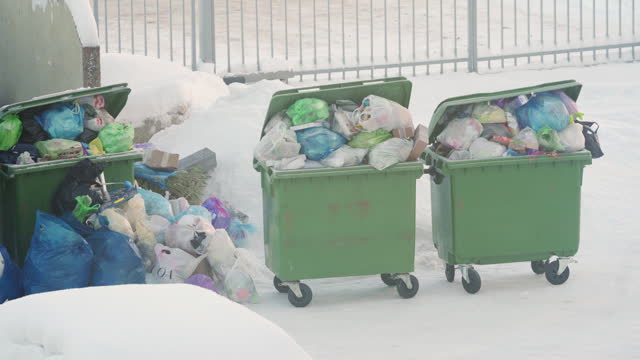 Overflowing garbage cans in winter, storage and collection of waste