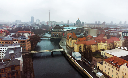 Drone point of view on  junction of Spree river and Kupferrgraben canal , Monbijou bridge next to Bode Museum.    Berlin Cathedral (Dome), and base of  Berlin Tv Tower( Fernsehturm) and Rotes Rathaus also. 3  Ukrainian flags over museums buildings!