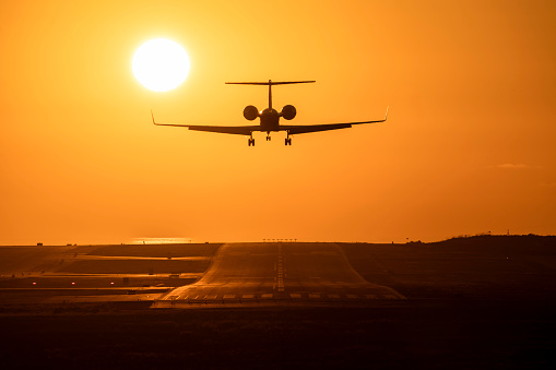 Small airplane taking off at sunset