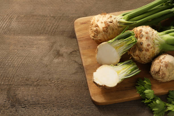 istock Fresh raw celery roots on wooden table, above view. Space for text 1927696361