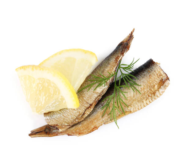 istock Tasty canned sprats, lemon and dill isolated on white, top view 1927703318