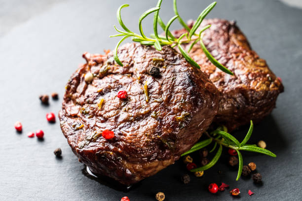 istock Beef medallions with spices and herbs at stone board. 1927746673
