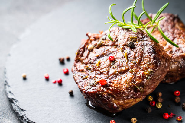istock Beef medallions with spices and herbs at stone board. 1927746674