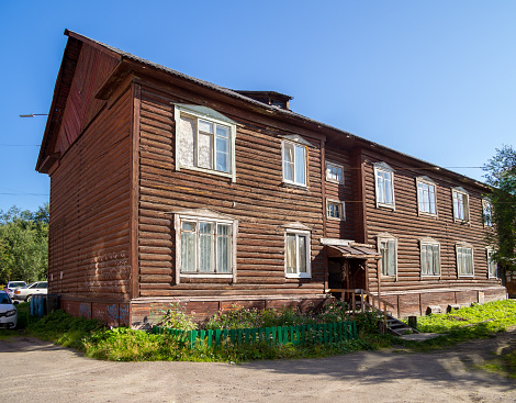 Murmansk, Russia - August 09, 2021: Two-storey two-entrance old log house, city of Murmansk