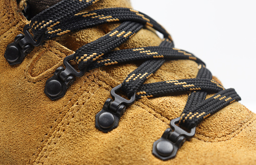 Close up macro of shoelace on yellow nubuck leather boots