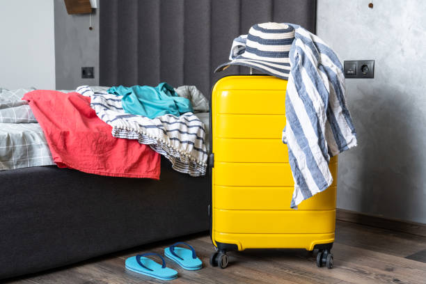 istock Suitcase with summer cloth and hat in the bedroom. 1927789566